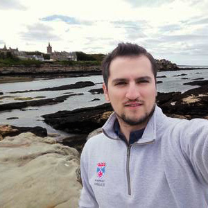 Giorgos on the shore at St Andrews, with the town behind him.
